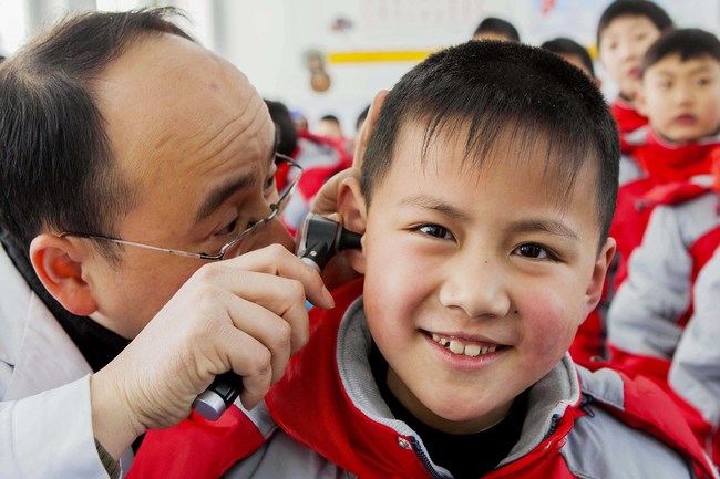 A student is having an ear examination, at a primary school, in Lianyungang, Jiangsu Province, on March 1, 2015. [File Photo: VCG]