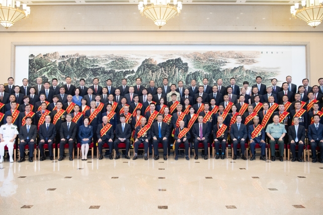 President Xi Jinping poses a group photo with representatives of veterans in Beijing on July 26, 2019. [Photo: Xinhua]