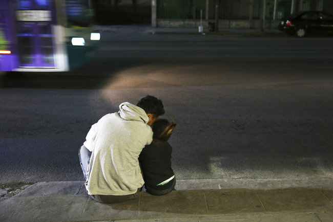 In this July 18, 2019 photo, a migrant father and daughter sit on the sidewalk after getting off a bus that brought them all the way from Nuevo Laredo to Monterrey, Mexico, Thursday, July 18, 2019. [Photo: AP]