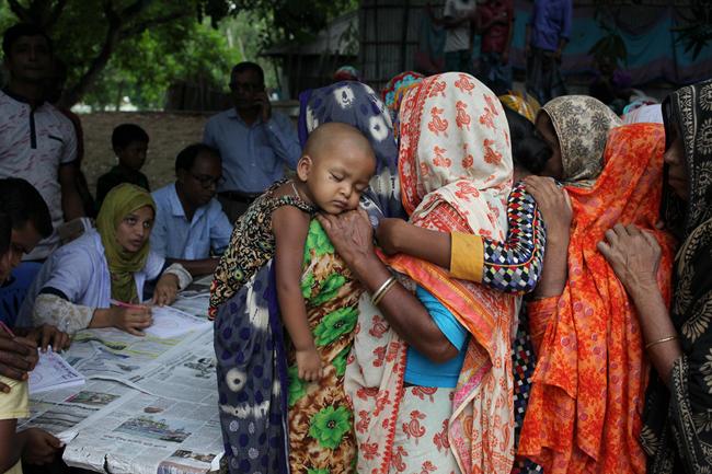 Flood affected people wait in a line to get primary medical treatment in Pachgachi, Kurigram, Bangladesh on 27 July 2019. [Photo: Syed Mahamudur Rahman/NurPhoto via ZUMA Press via IC]