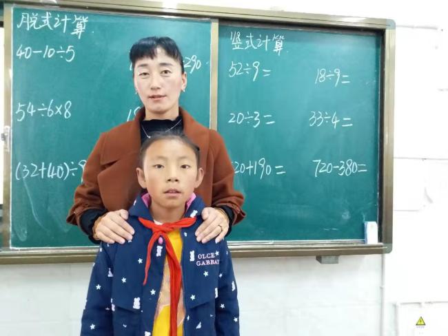 Karma tested positive for congenital heart disease received surgery half a year ago. She was with her math teacher Tenzin in the classroom. [Photo: from China Plus] 