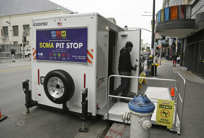 An attendant exits a "Pit Stop" public toilet on Sixth Street, Thursday, Aug. 1, 2019, in San Francisco. A 5-year-old portable toilet program in San Francisco that provides homeless people with a private place to go has expanded to 25 locations in the city and has spread to Los Angeles. Not everyone who uses the “Pit Stop” toilets is homeless, but advocates say steam cleaning requests have dropped in surrounding areas. [Photo: AP/Eric Risberg]