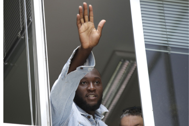 Soccer forward Romelu Lukaku waves at Inter Milan supporters from a window of the Italian Olympic Committee's headquarters, in Milan,Italy, Thursday, Aug. 8, 2019. [Photo: IC]