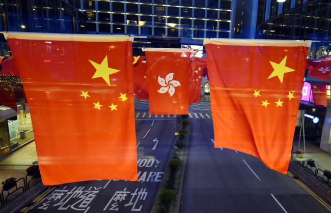 Vehicles drive under flags of China and Hong Kong Special Administrative Region (HKSAR) of the People's Republic of China decorated to mark the 20th anniversary of Hong Kong's return to the motherland in HKSAR on June 25, 2017. [File Photo: IC]