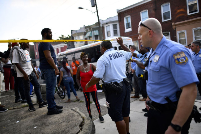 Police officers direct citizens to move back near the scene of a shooting on August 14, 2019 in Philadelphia, Pennsylvania. [Photo: Getty Images/Mark Makela]