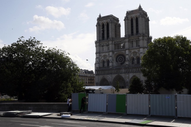 Workers install high fences on a bridge around Notre Dame cathedral in Paris, Tuesday, Aug. 13, 2019. [Photo: AP]