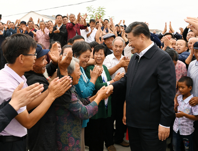 Xi Jinping, general secretary of the Communist Party of China Central Committee, shakes hands with local residents in Gulang County, Gansu Province, August 21, 2019. [Photo: Xinhua]
