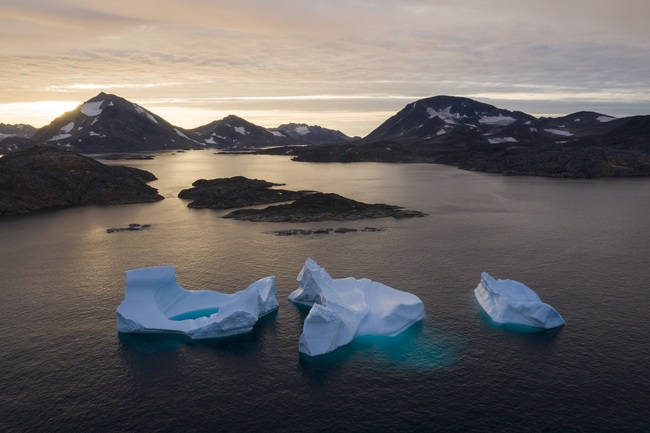 In this Aug. 16, 2019, photo, large Icebergs float away as the sun rises near Kulusuk, Greenland. Scientists are hard at work, trying to understand the alarmingly rapid melting of the ice. [Photo: AP]