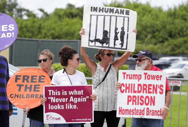 In this July 15, 2019, file photo, protesters hold signs outside of the Homestead Temporary Shelter for Unaccompanied Children while members of Congress tour the facility in Homestead, Fla. [File photo: AP]