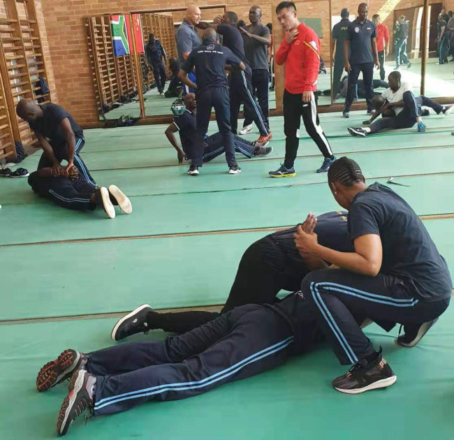 JMPD officers wrestle on the ground during a training exercise conducted by Fujian Police College trainers. [Photo: Joburg Public Safety]
