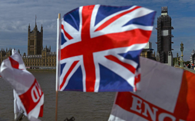 The Palace of Westminster, housing the Houses of Parliament, is pictured from Westminster Bridge with a Union flag in the foreground, in central London on August 28, 2019. [Photo: VCG]