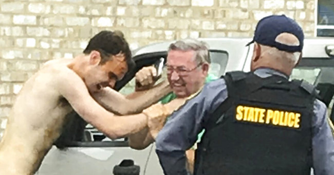 Matthew Thomas Bernard puts his hands on Keeling Baptist Church groundskeeper Loyd Gauldin, as a state police officer attempts to take him into custody on Tuesday, Aug. 27, 2019 in Keeling, Va. [Photo: AP]