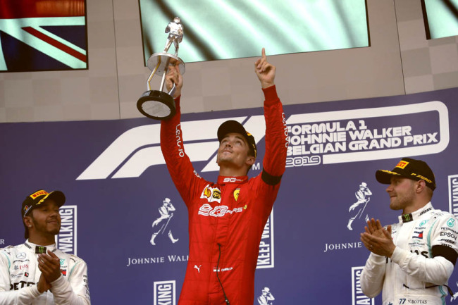 Ferrari driver Charles Leclerc of Monaco, center, lifts the trophy and pays tribute to Anthoine Hubert, who died in a crash during the F2 race one day earlier, after finishing first in the Belgian Formula One Grand Prix in Spa-Francorchamps, Belgium, Sunday, Sept. 1, 2019. [Photo: IC]