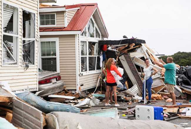 Residents of the Boardwalk RV Park discuss the path of a possible waterspout or tornado, generated by Hurricane Dorian, struck the area, Thursday, Sept. 5, 2019, in Emerald Isle, N.C. [Photo: AP /Julia Wall/The News & Observer]