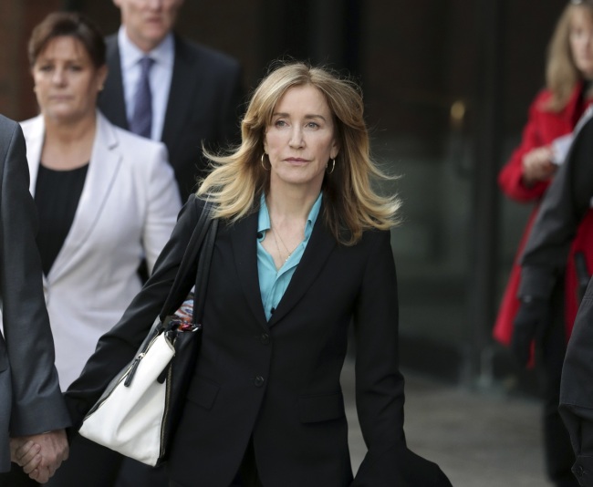 File Photo: This April 3, 2019 file photo shows actress Felicity Huffman departing federal court in Boston after facing charges in a nationwide college admissions bribery scandal. [Photo: AP/Charles Krupa]