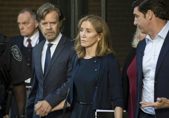 Actress Felicity Huffman, escorted by her husband William H. Macy (L), exits the John Joseph Moakley United States Courthouse in Boston, where she was sentenced by Judge Talwani for her role in the College Admissions scandal on September 13, 2019. Actress Felicity Huffman gets 14 days jail in US college admissions scandal. [Photo: AFP/Joseph Prezioso]