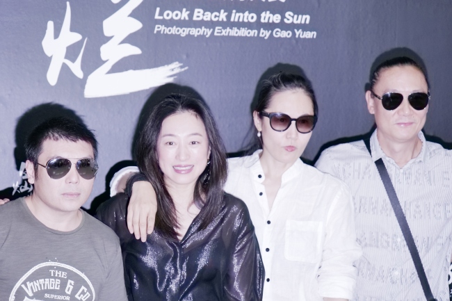 Gao Yuan (2nd from right) poses in front of her exhibition poster along with her friends, at the opening ceremony of her Rock photography event in Beijing on Wednesday, September 18, 2019. [Photo: China Plus]