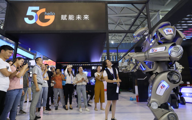 People look at a robot developed with 5G technologies at an exhibition of the 2019 World Manufacturing Convention on Thursday, September 19, 2019. [Photo: IC]