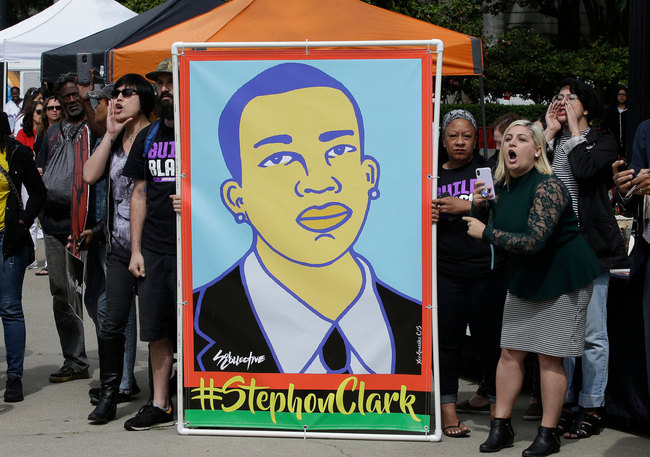 In this April 9, 2018 file photo protesters display an image of Stephon Clark at a crime victims rights rally, at the Capitol in Sacramento, Calif. [Photo: AP]