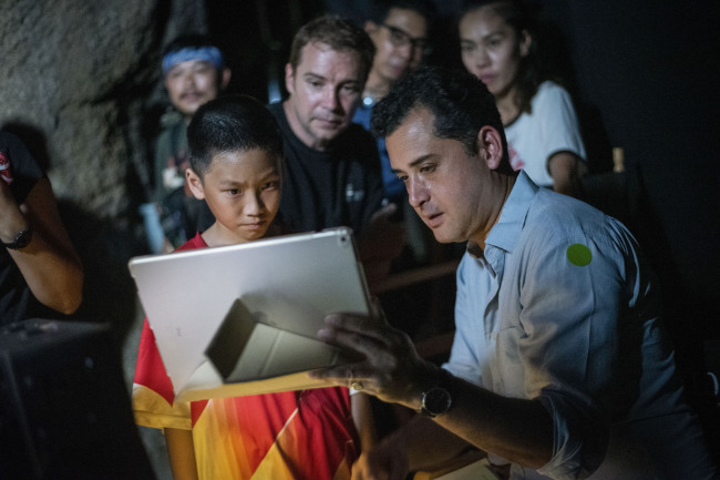 In this Nov. 14, 2018, photo provided by De Warrenne Pictures, director Tom Waller, right, talks to actors for a scene of his film "The Cave" in Thailand. [Photo: AP]