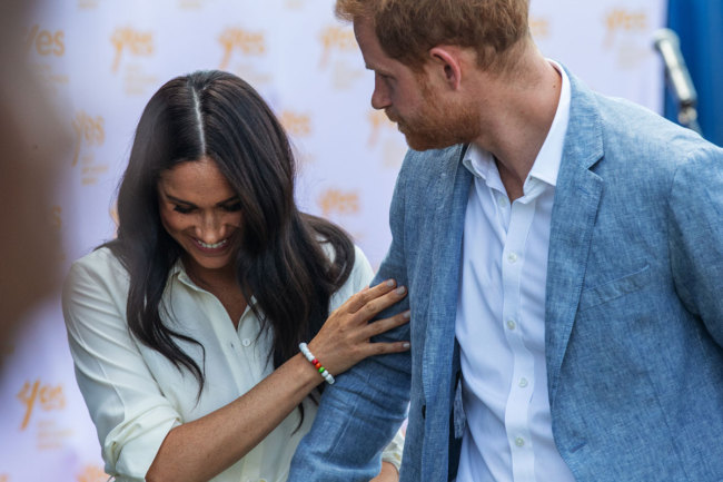 Britain's Prince Harry, Duke of Sussex(R) and Meghan, Duchess of Sussex(L) leave the Youth Employment Services Hub in Tembisa township, Johannesburg, on October 2, 2019. [Photo: AFP]