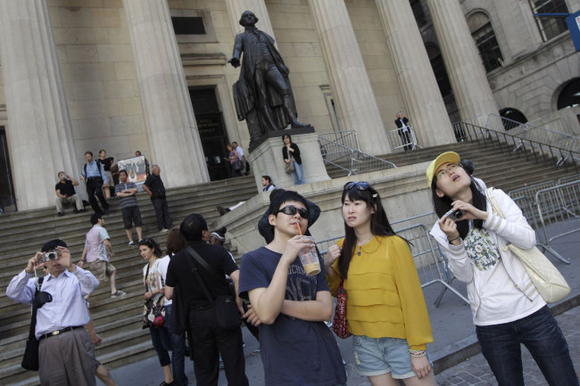 A group of tourists from China take in the sights of the New York Stock Exchange and Federal Hall National Memorial. [File photo: IC]