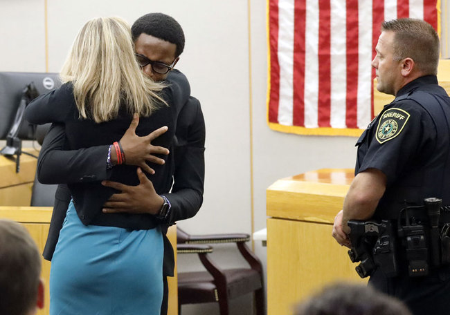 Botham Jean's younger brother Brandt Jean hugs convicted murderer and former Dallas Police Officer Amber Guyger after delivering his impact statement to her after she was sentenced to 10 years in jail, Wednesday, Oct. 2, 2019, in Dallas. Guyger shot and killed Botham Jean, an unarmed 26-year-old neighbor in his own apartment last year. She told police she thought his apartment was her own and that he was an intruder. [Photo: Tom Fox/The Dallas Morning News via AP]