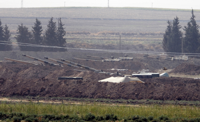 In this Sunday, Oct. 6, 2019 photo, Turkish forces artillery pieces are seen on their new positions near the border with Syria in Sanliurfa province, Turkey. [Photo: DHA via AP]