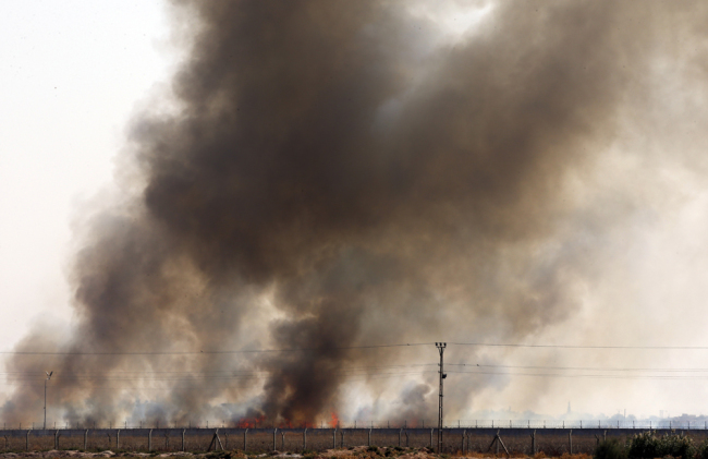 In this photo taken from the Turkish side of the border between Turkey and Syria, in Akcakale, Sanliurfa province, southeastern Turkey, smoke billows from fires on targets in Tel Abyad, Syria, caused by bombardment by Turkish forces, Sunday, Oct. 13, 2019. [Photo: AP/Lefteris Pitarakis]