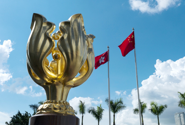 Flags of the People's Republic of China and the Hong Kong Special Administrative Region fly next to the statue of a Golden Bauhinia flower in Hong Kong on June 7, 2017. [File photo: IC]