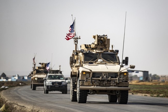 US military vehicles drive on a road after US forces pulled out of their base in the Northern Syriain town of Tal Tamr on October 20, 2019. [Photo: AFP/Delil SOULEIMAN]