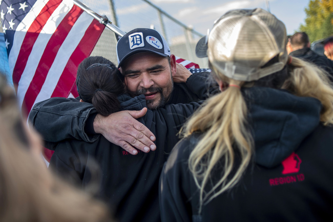 Saginaw resident Michael Perez and other members celebrate during the 40th and final day of the United Auto Workers strike against General Motors outside of the Flint Assembly Plant, Friday, Oct. 25, 2019, in Flint, Mich. Striking General Motors factory workers are putting down their picket signs after approving a new contract that will end a 40-day strike that paralyzed the company's U.S. production. [Photo: Jake May/MLive.com/The Flint Journal via AP]