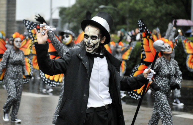 People take part in the Day of the Dead parade along Reforma avenue in Mexico City, on October 27, 2019. [Photo: AFP/Claudio Cruz]