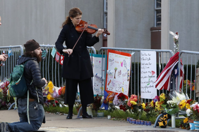 Monique Mead plays her violin on the sidewalk outside the Tree of Life synagogue in Pittsburgh on Sunday, Oct. 27, 2019, the first anniversary of the shooting at the synagogue that killed 11 worshippers. [Photo: AP via IC/Gene J. Puskar]