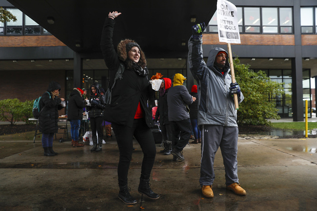 Chicago Teachers Union members, from left, Genevieve Roland (cq), a fifth year physics teacher and science department head, and Richie Foreman (cq), a second year counselor, stand on the picket line outside of Roberto Clemente Community Academy in Chicago on the tenth school day of the teachers strike, seen here on Wednesday, Oct. 30, 2019. [Photo: AP]