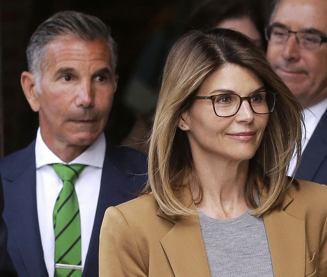 In this April 3, 2019, file photo, actress Lori Loughlin, front, and husband, clothing designer Mossimo Giannulli, left, leave federal court in Boston after facing charges in a nationwide college admissions bribery scandal. [Photo: AP]