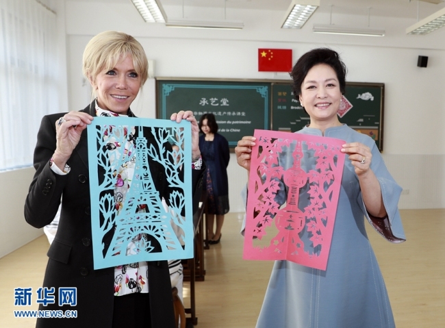 Peng Liyuan, wife of Chinese President Xi Jinping and Brigitte Macron, wife of French President Emmanuel Macron visit a local middle school in Shanghai on Tuesday, November 05, 2019. [Photo: Xinhua]