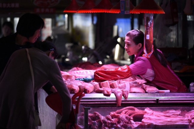 A vendor (R) sells pork at a market in Beijing on October 15, 2019.[Photo: AFP/WANG Zhao] 