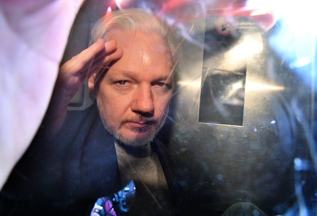 File Photo: WikiLeaks founder Julian Assange gestures from the window of a prison van as he is driven out of Southwark Crown Court in London on May 1, 2019, after having been sentenced to 50 weeks in prison for breaching his bail conditions in 2012. [Photo: AFP/Daniel LEAL-OLIVAS]