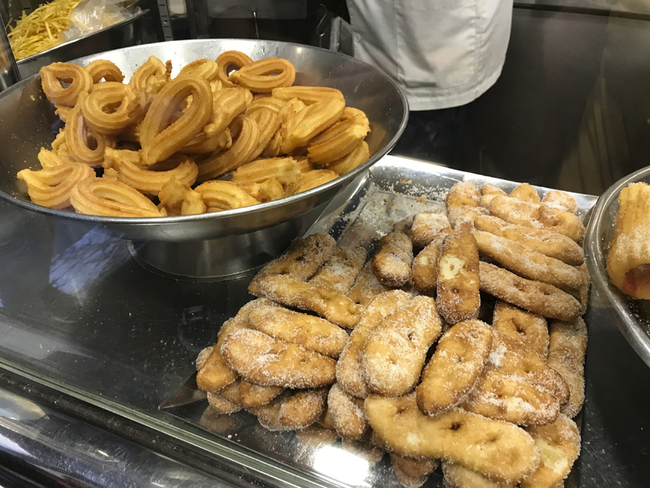 This Oct. 7, 2019 photo shows churros and other fried treats on display at Xurreria, a small shop famous for its churros and chocolate, in the Gothic Quarter of Barcelona, Spain. [Photo: Courtney Bonnell via AP]