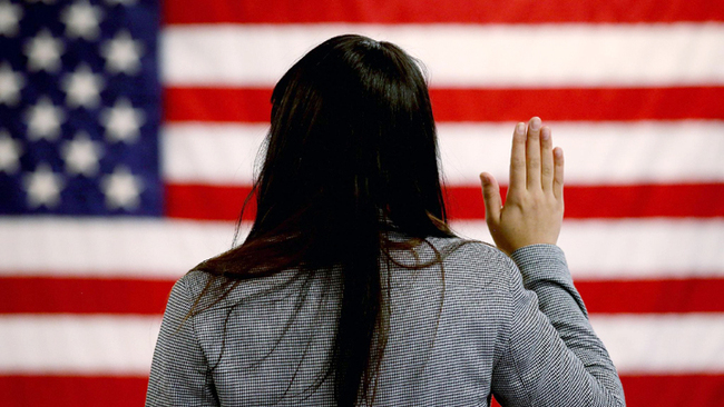 A woman takes the oath of allegiance during a naturalization ceremony at the district office of the U.S. Citizenship and Immigration Services (USCIS) on January 28, 2013 in Newark, New Jersey. [File Photo: Getty Editorial via VCG]