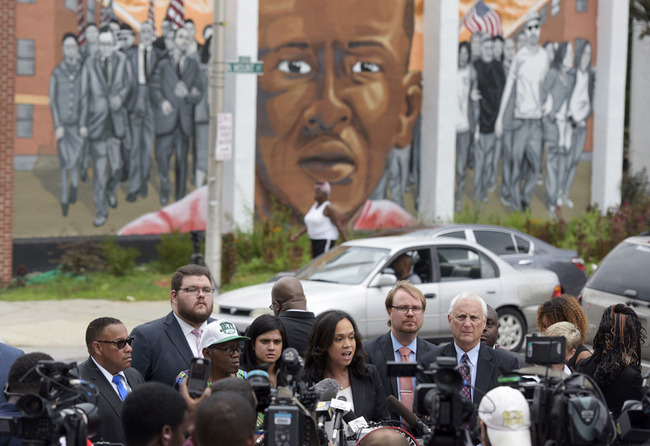 In this July 27, 2016, file photo, with a mural depicting Freddie Gray in the background, Baltimore State's Attorney Marilyn Mosby, center, speaks during a news conference after her office dropped remaining charges against the three Baltimore police officers who were still awaiting trial in Gray' death in Baltimore. [Photo: AP]