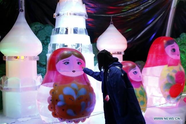 A woman views an ice sculpture during an exhibition in Galveston,Texas on Dec. 1, 2019. [Photo: Xinhua]