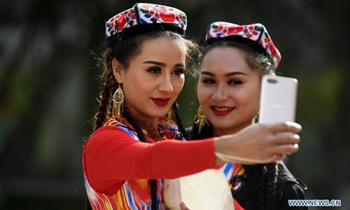 Actresses take a selfie during a culture and tourism festival themed on Dolan and Qiuci culture in Awat County of Aksu Prefecture, northwest China's Xinjiang Uygur Autonomous region, Oct. 25, 2019. The festival kicked off recently in Aksu Prefecture. [Photo: Xinhua/Sadat]