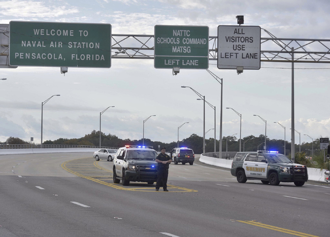 Police vehicles block the entrance to the Pensacola Air Base, Friday, Dec. 6, 2019 in Pensacola, Florida. The U.S. Navy is confirming that a shooter is dead and several injured after gunfire at the Naval Air Station in Pensacola. [Photo: Tony Giberson/ Pensacola News Journal via AP]