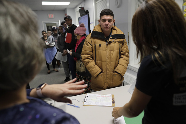 In this Wednesday, Dec. 4, 2019 photo Helison Alvarenga, of Brazil, center, speaks with volunteers Marcia Previatti, front left, and Arlene Vilela, front right, at the New England Community Center, in Stoughton, Mass. [Photo: AP/Steven Senne]