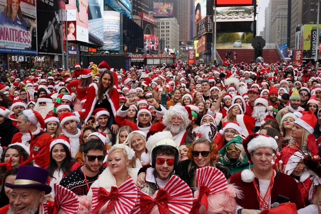 Revellers gather for the start of the Annual SantaCon Bar Crawl at Father Duffy Square, a section of Times Square, on December 14, 2019, in New York. SantCon is an event where people make donations to charitable causes and dress up as a Christmas character and visit bars around the city. [Photo: AFP]