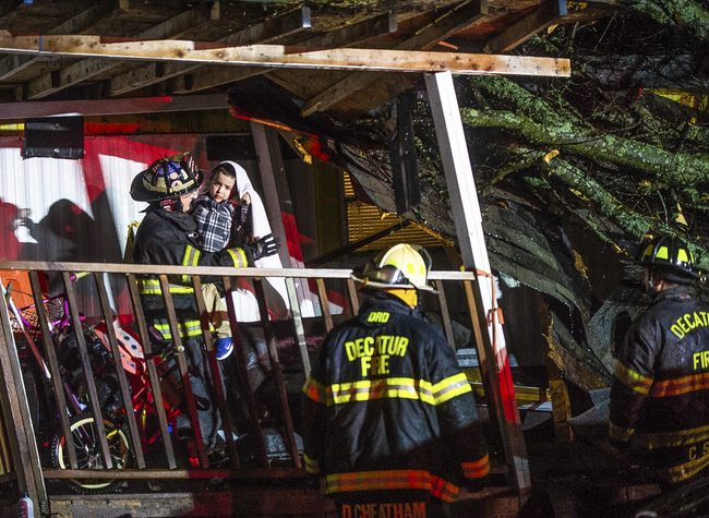 Firefighter Ryan Gilley, left, helps evacuate a mobile home with Decatur Fire & Rescue members after a tree fell on the home in Decatur, Ala., Monday, Dec. 16, 2019. [Photo: AP]