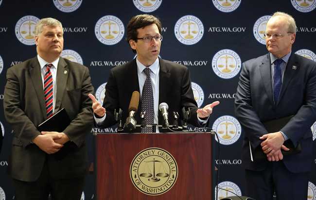 Washington state Attorney General Bob Ferguson, center, speaks as King County Prosecuting Attorney Dan Satterberg, left, and Thurston County Prosecuting Attorney Jon Tunheim look on during a news conference about Ferguson's lawsuit challenging a Trump Administration practice of ICE arrests at courthouses Tuesday, Dec. 17, 2019, in Seattle. [Photo: AP]