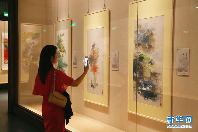 A citizen takes photos of works by Hou Beiren, a renowned contemporary Chinese painter, at a Liaoning Provincial Museum exhibition in northeast China on September 4, 2018. [Photo: Xinhua]